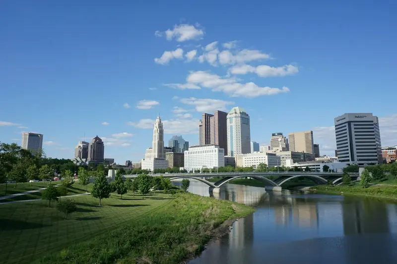 Downtown Columbus skyline beyond the Scioto River and a bridge on a clear day